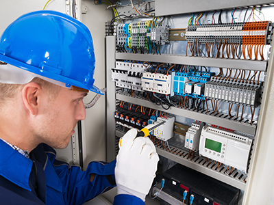 BMS Projects technician working in a control panel for mechanical services in a commercial building