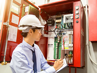 Fire Indication Panel Programming technician performing programmed maintenance