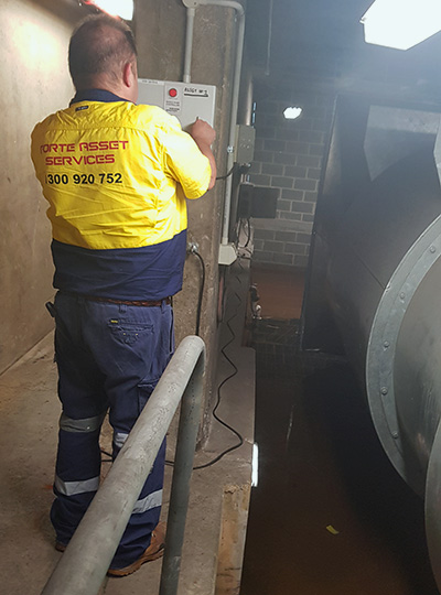 Forte asset services Team member working on sump pump after basment flood in Sydney CBD building