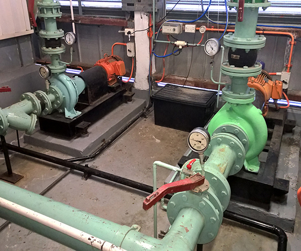 HVAC Mechanical services in the plant room of a Chatwood building showing condenser water pumps one and two both in operation and controlled by the building automation system, Sydney