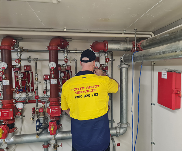 Forte asset services fire protection maintenace technician performing monthly preventative maintenace checks upon a sprinkler system header and alarm valves in Sydney