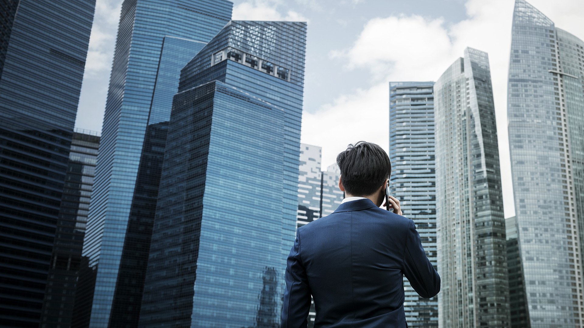 City Commercial Hi-rise buildings in a cluster with a forte asset services executive standing in front talking on a mobile phone. Sydney Melbourne Canberra